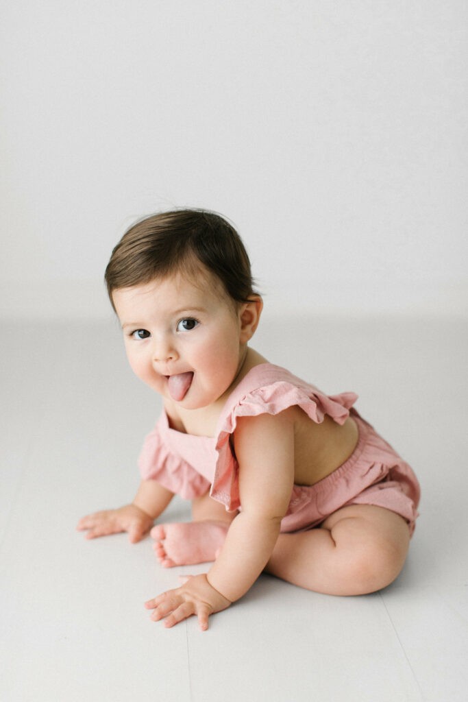 Cheeky baby pokes out tongue during a baby photography session